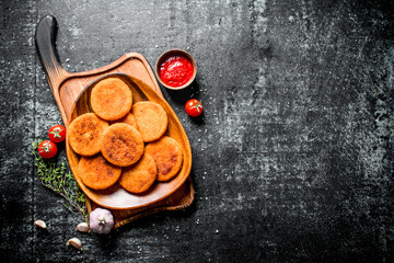 Fish cutlets on a plate with thyme,garlic and tomato sauce.