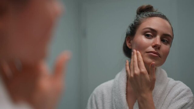 Young woman taking care of her skin, morning beauty routine concept.