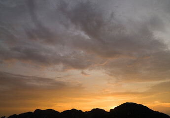 Dark hills followed by setting sun and dramatic sky