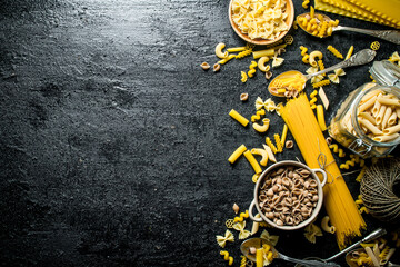 Different types of pasta dry the spoon and bowl.