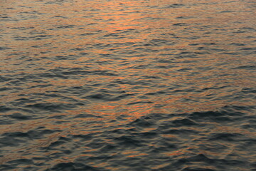 Sunset light reflection in sea wave , close up texture for background.