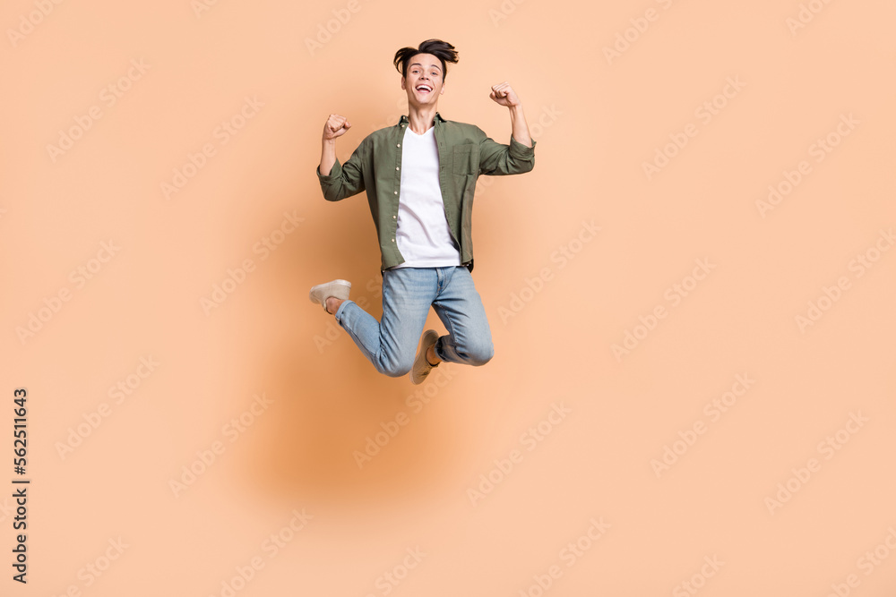 Sticker full length photo of young funky guy jump carefree fists up celebrate fists up overjoyed wear khaki 