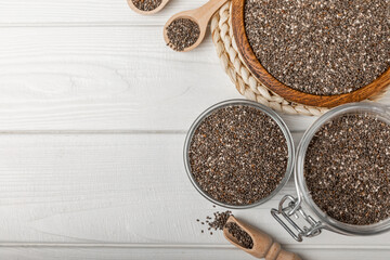 Chia seeds in jar and spoons on white texture wood. Superfood. Antioxidant. Healthy food. Proper nutrition. Diet concept. Place for text. Place to copy. selective focus.