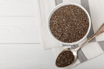Chia seeds in jar and spoons on white texture wood. Superfood. Antioxidant. Healthy food. Proper nutrition. Diet concept. Place for text. Place to copy. selective focus.