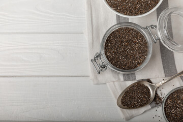 Chia seeds in jar and spoons on white texture wood. Superfood. Antioxidant. Healthy food. Proper nutrition. Diet concept. Place for text. Place to copy. selective focus.