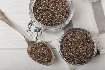 Chia seeds in jar and spoons on white texture wood. Superfood. Antioxidant. Healthy food. Proper nutrition. Diet concept. Place for text. Place to copy. selective focus.