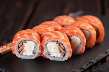 Sushi roll philadelphia with salmon and eel and cream cheese on black background close-up. Sushi menu. Japanese food concept