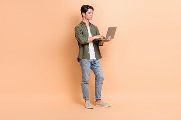Full length cadre photo of young freelancer copywriter man wear trendy outfit online browsing netbook email isolated on beige color background