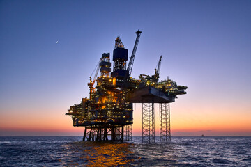 Offshore oil and gas platform in the sea at sunset. 
Jack up rig crude oil production in ocean. 