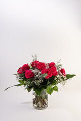 Red roses bouquet in a glass vase in white background