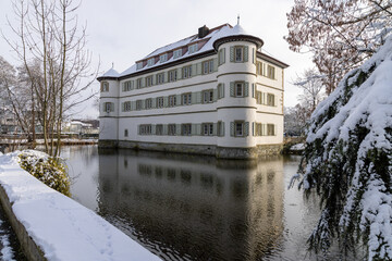 Fototapeta na wymiar old moated castle of Bad Rappenau in winter with snow, moat and reflection