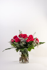 Red roses bouquet in a glass vase in white background