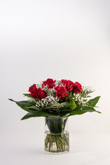 Red roses bouquet in a glass vase in white background