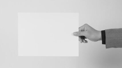 The male hand is holding the A4 paper board on white background.