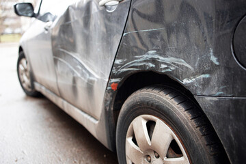 A lot of scratches on a car close up. Side of black car get damaged.