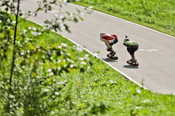 Young people skateboarding outdoors on the road. Young man and woman practicing skating on a rural road.