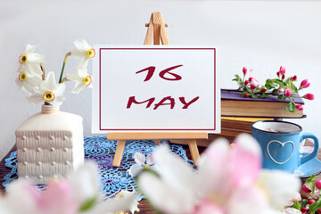  Calendar for May 16: the name of the month May in English, the numbers 16 written on paper, among...