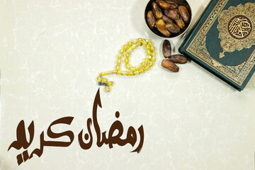 Ramadan, eid concept. lantern with Holy Quran with Arabic calligraphy meaning of Al Quran and dates fruit , rosary muslim