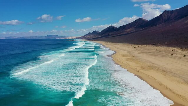 Amazing Cofete beach with endless horizon. Volcanic hills in the background and Atlantic Ocean. Cofete beach, Fuerteventura, Canary Islands, Spain. Playa de Cofete, Fuerteventura, Canary Islands.