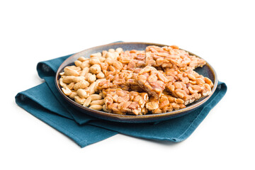 Sweet peanut brittle on plate. Tasty peanuts in caramel isolated on white background.