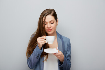 Business woman wearing suit holding coffee cup with saucer.