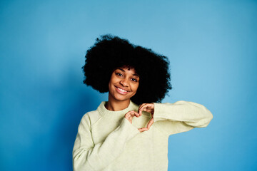 Smiling black woman showing a heart gesture