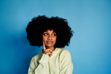 Fototapeta na wymiar pensive Charming black woman on blue background