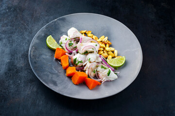 Traditional Peruvian gourmet ceviche sea bass filet piece with sweet potatoes and cancha marinated...