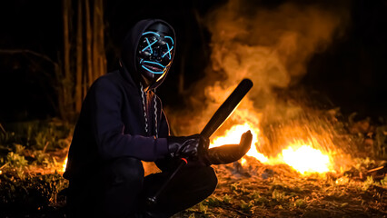 Masked man with a baseball bat on the background of fire. Fire Blast back