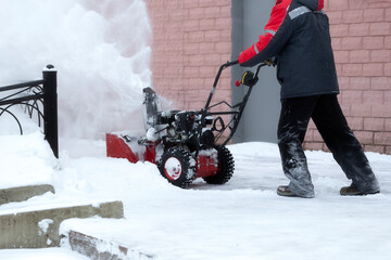 A portable snow blower powered by gasoline. Snow removal in winter.