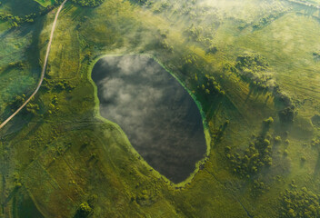 Lake in fog, drone view. Morning mist haze in rural. Rural landscape with lakes. Drink water. Village at lake in mist haze. Freshwater Lakes. Fog over country with lake. Country in Foggy landscape.