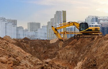 Obraz premium Excavator dig the trenches at a construction site. Trench for laying external sewer pipes. Sewage drainage system for a building. Excavator on groundwork and dig foundation at construction site.