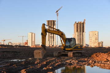 Excavator dig ground at construction site. Dig foundation. Construction of residential buildings,...