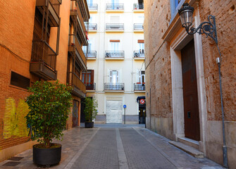 City street of the Valencia, Spain. Road traffic, cars on road, people and buildings. Urban building architecture, square, trees in parks and panarama. Car in motion on city streets. Capital center.