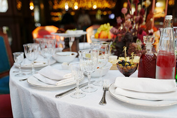 table setting for a festive dinner. empty wine glasses, tableware and snacks.