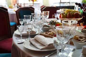 table setting for a festive dinner. empty wine glasses, tableware and snacks.