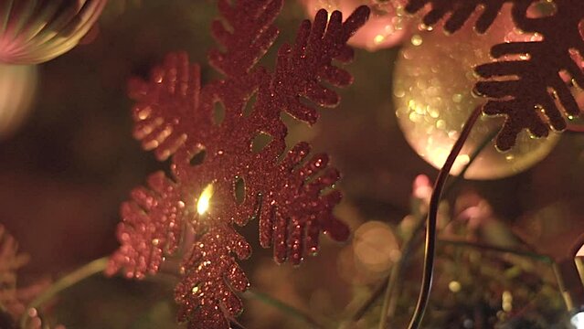 Red Christmas snowflake ornament hanging from Christmas tree