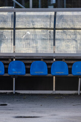 Blue plastic seats of a substitute bench.