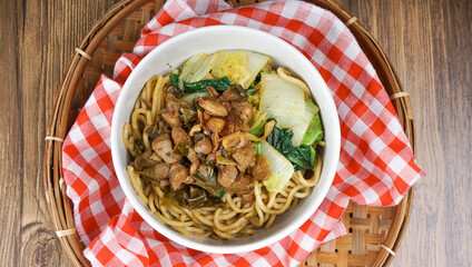 Flat Lay of Mie Ayam as Indonesia chicken noodles topped with diced chicken, green vegetables and chili sauce