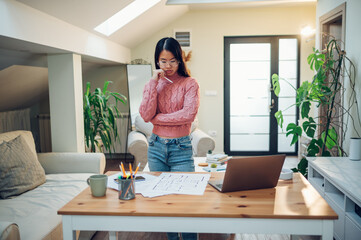 Vietnamese Asian woman using laptop while working at home