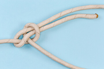 Rope knot bowline close-up on a blue background