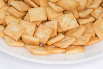 Salty crackers square shape on dish, fragment close-up