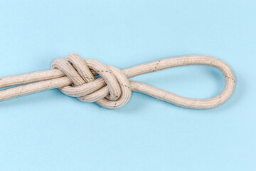Rope knot аigure-eight loop on blue background, close-up