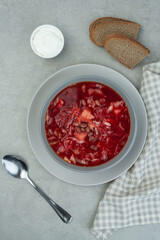 Ukrainian vegetarian borscht with beans on a gray background