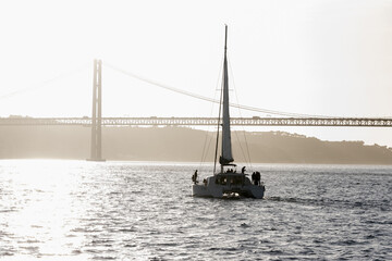 Sailboat sails the river heading for the bridge