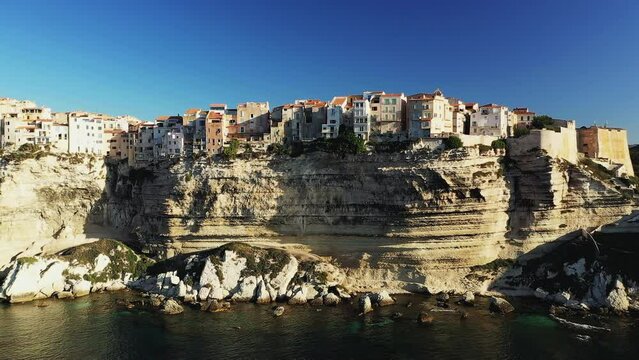 The town of Bonifacio above the chalk cliffs in the green countryside , Europe, France, Corsica, towards Ajaccio, by the Mediterranean Sea, in summer, on a sunny day.