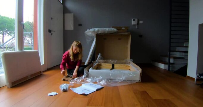 In their newly moved empty house, the mother wearing home clothes is installing the new seat with her baby. Fun and timelapse video.The process from start to finish.