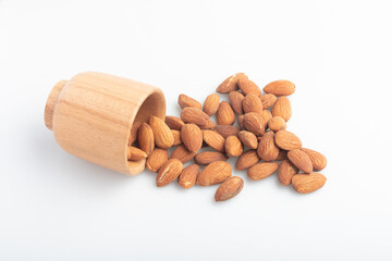 Almonds in a wooden cup on a white background