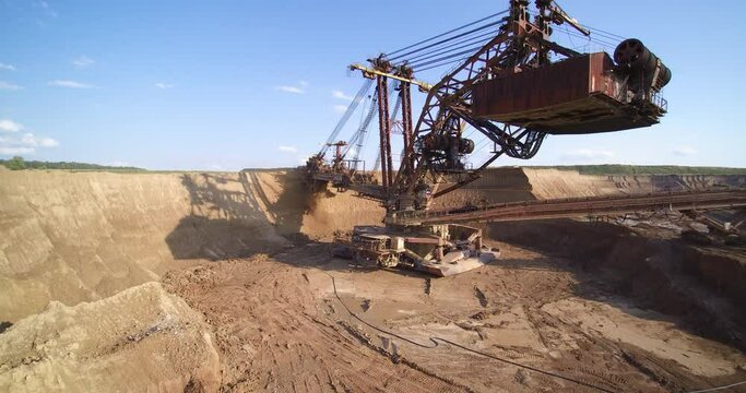 famous huge brown bucket wheel excavator scoops overburden ground digging quarry under blue sky aerial view