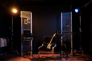 Empty music recording studio with guitar on chair, next to amps, sound amplifier equipment. Nobody...